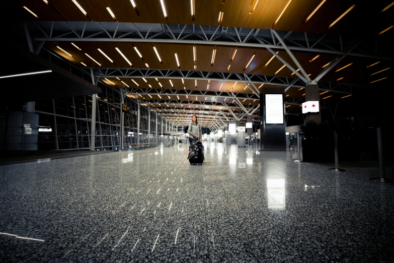 an empty walkway in a dark airport with the luggage carousel covered in lights