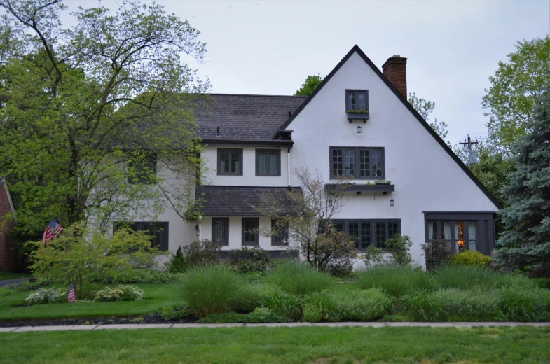 a large white house surrounded by greenery in the foreground