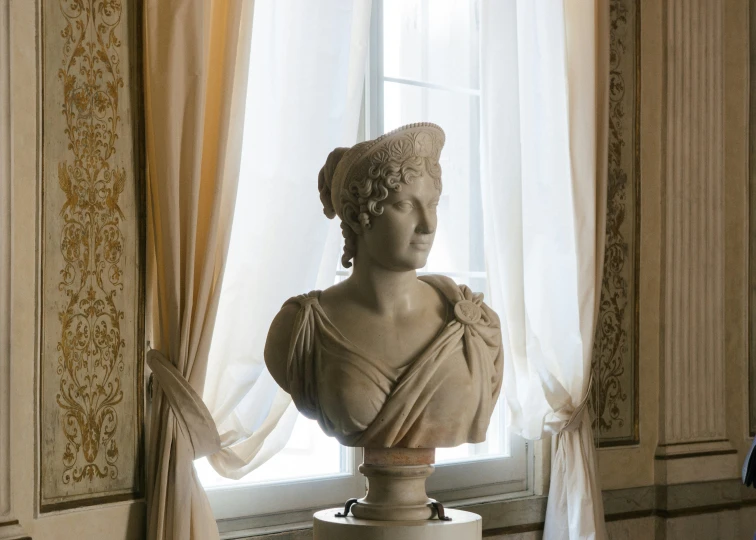 statue of a woman near a window with curtains on either side