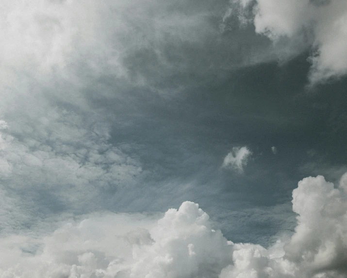 a cloudy sky is in the foreground with a jet liner visible