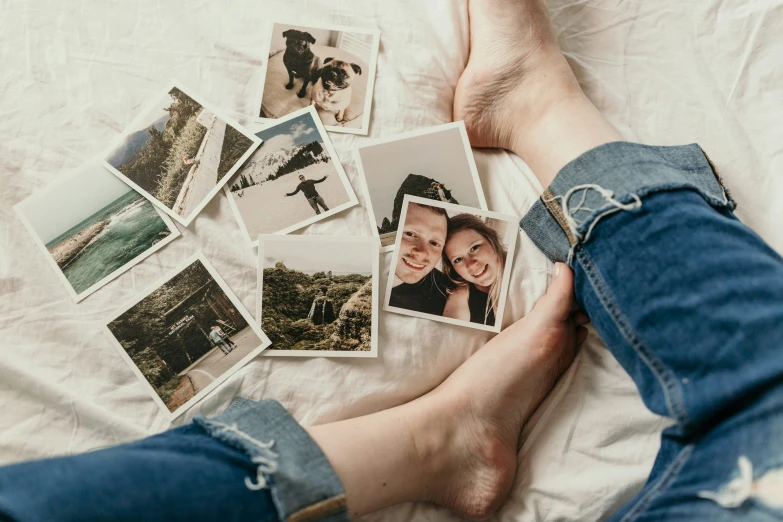 some polaroid pictures are sitting on a person's stomach