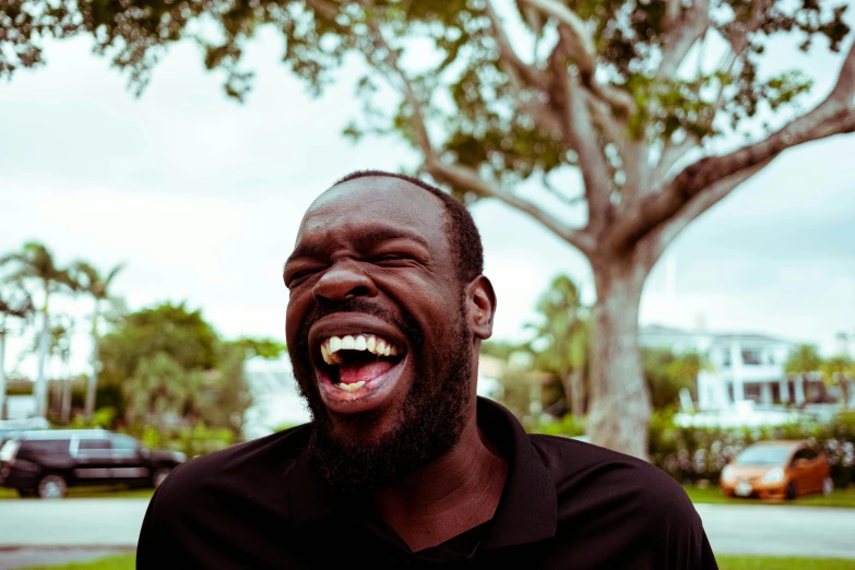 a man with a beard and black shirt laughing
