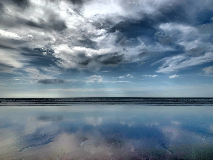 some clouds floating over the water at dusk