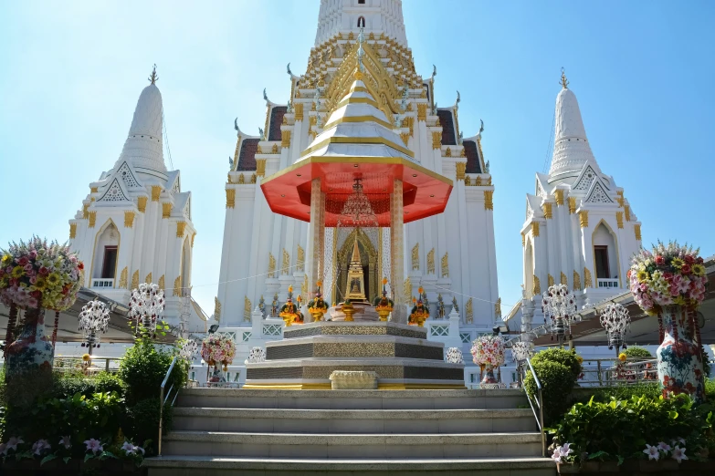 a gold - trimmed white building with steps and a pagoda