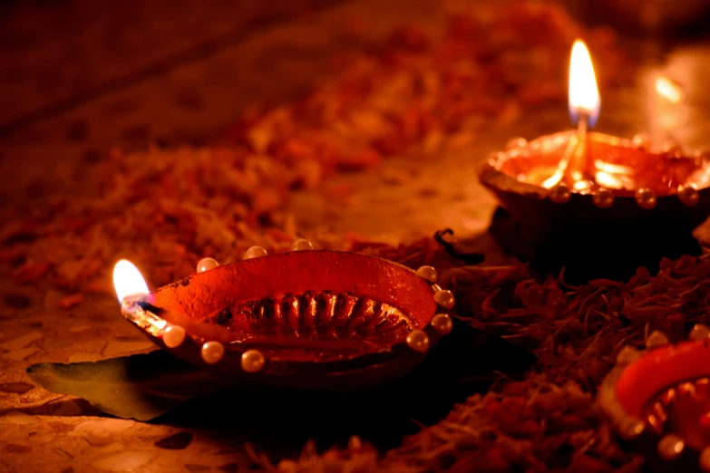 three decorative bowls with lit candles placed on the floor