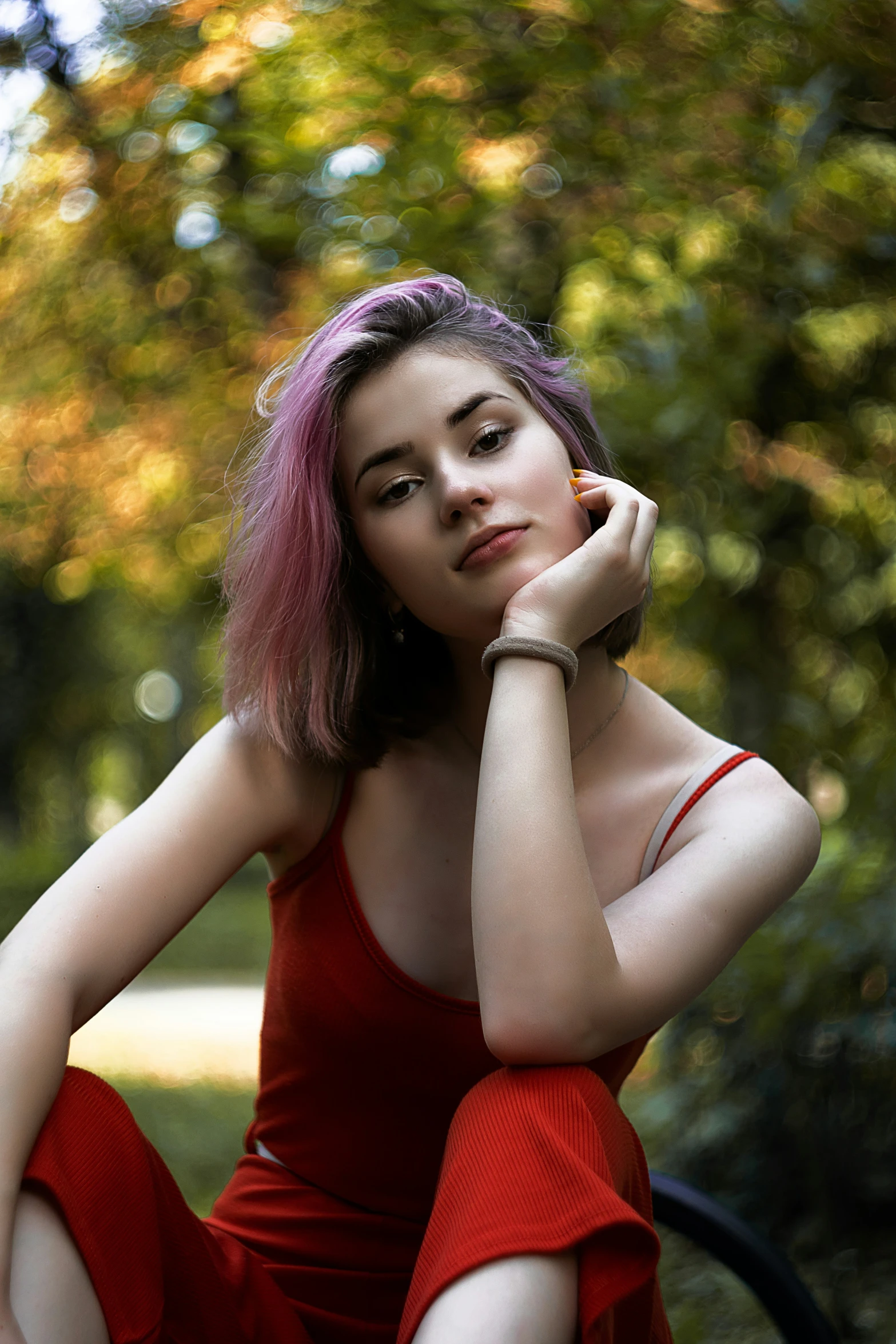 a person sitting on the ground with her hands on her chin