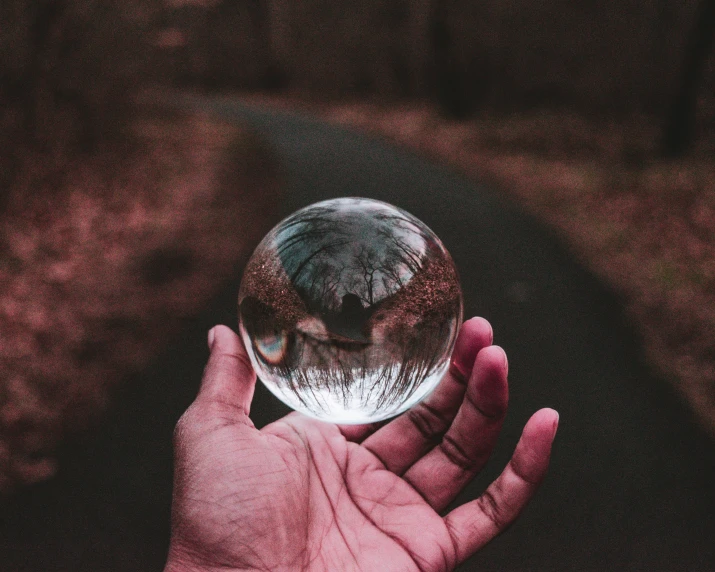 person holding small crystal ball in their hands