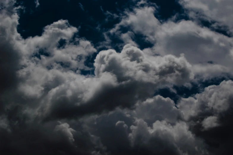 an airplane flies through a dark, cloudy sky