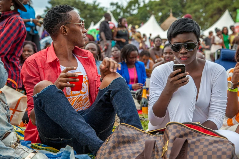 some people sitting and using cell phones while others watch