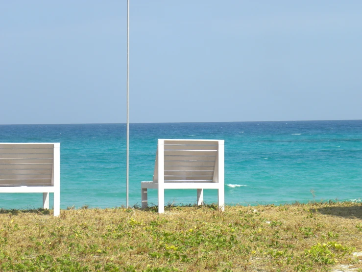 two chairs are sitting next to each other on a beach