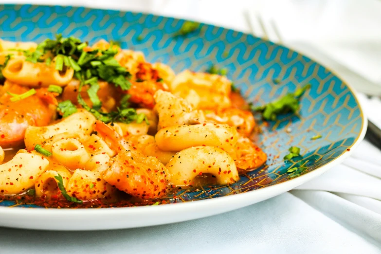 a blue plate topped with pasta and vegetables