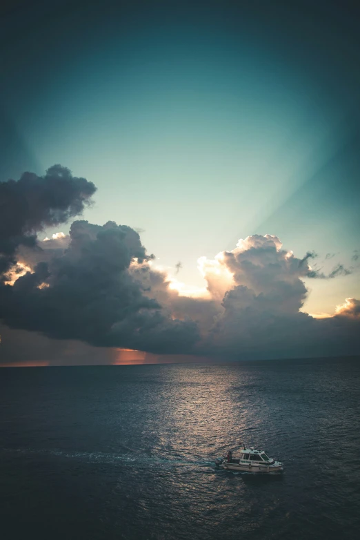 a boat sails in the water near clouds