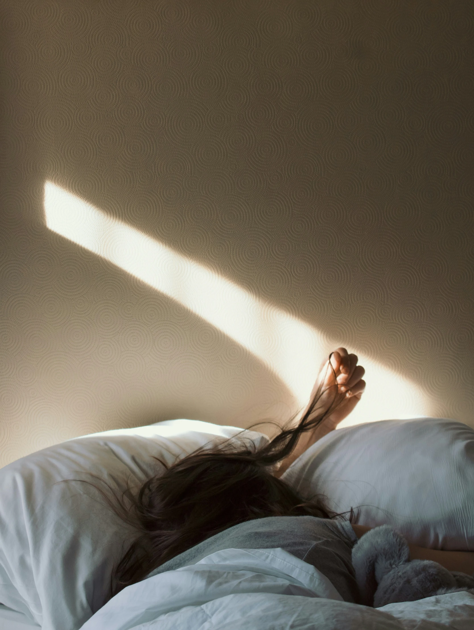 a woman laying on a bed under a white sheet