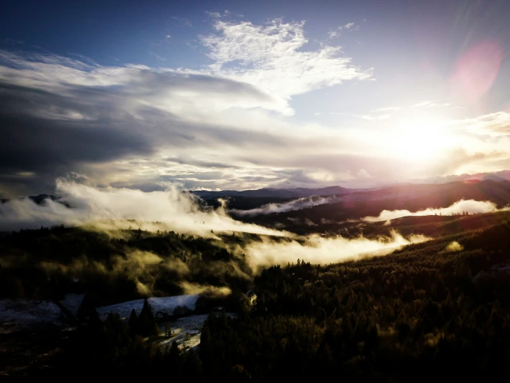 the sun is rising over the mountain range