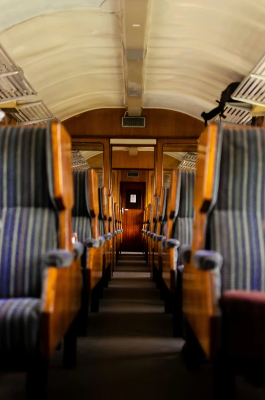 the inside of a passenger train car with striped seats