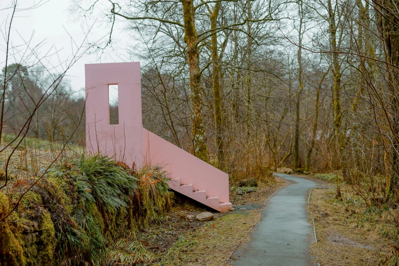 a pink monument is situated in the middle of a path