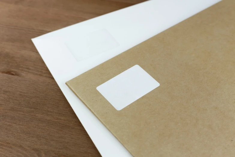 paper, a square, and a piece of cardboard are laying on top of a table