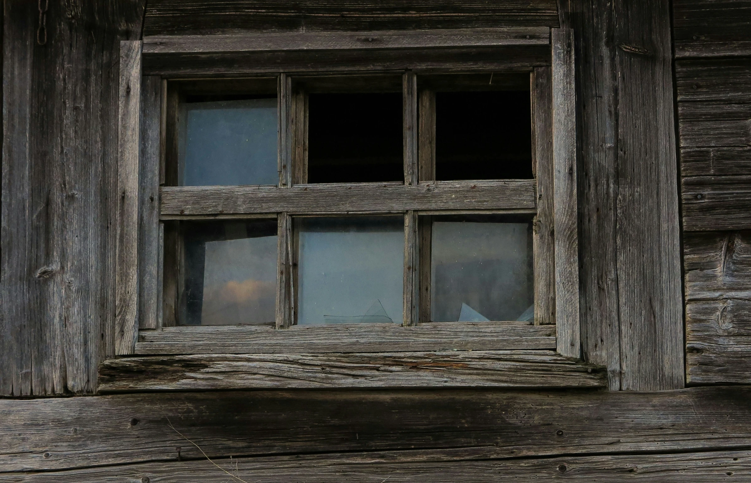 the corner of an old wooden window with windowsills