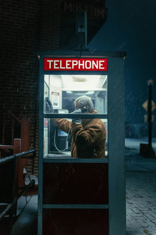 man in a telephone booth at night time