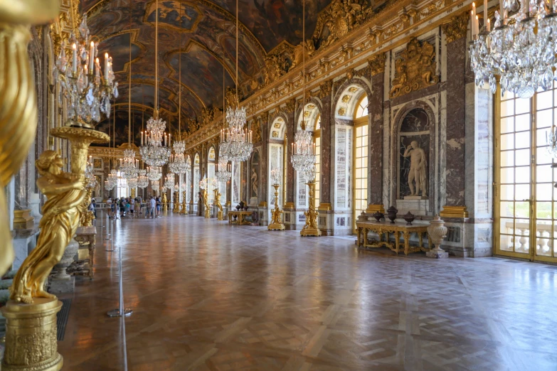 a ballroom with chandeliers and gilded walls