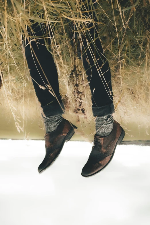 a pair of black shoes that are standing on snow