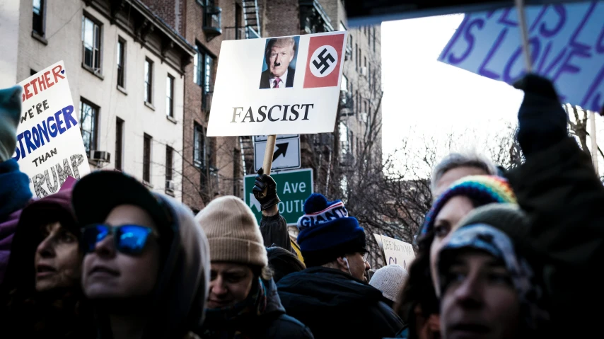 large group of people on the street holding signs