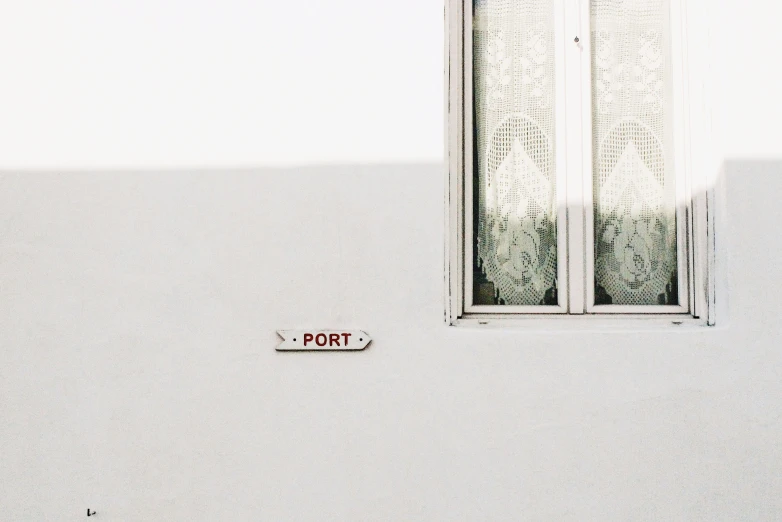 a red port sign sitting in the corner of a building