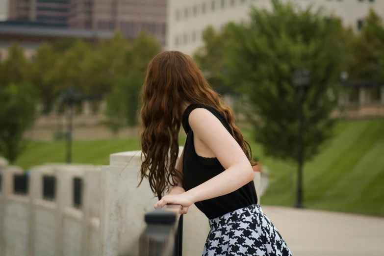 a woman with long red hair walking on a sidewalk