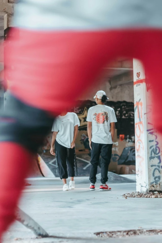 two men standing next to each other near a skateboard ramp