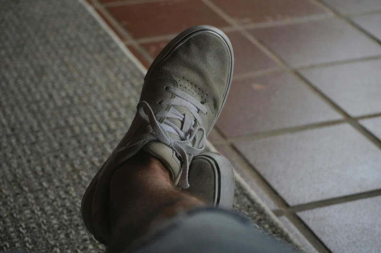 a person standing on a tile floor next to red bricks