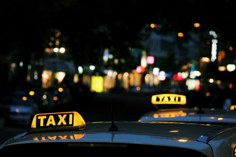 a couple of taxis that are parked in a lot