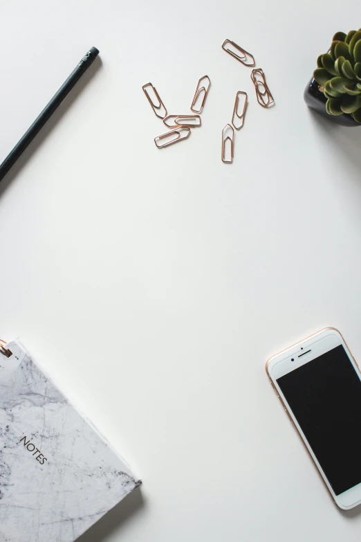 desk with cell phone and notebook with clips to hold the clips