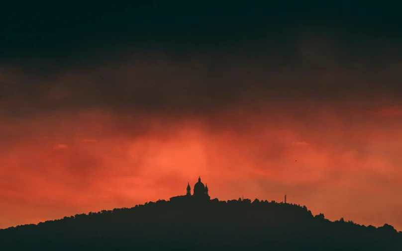 a building on top of a hill during sunset