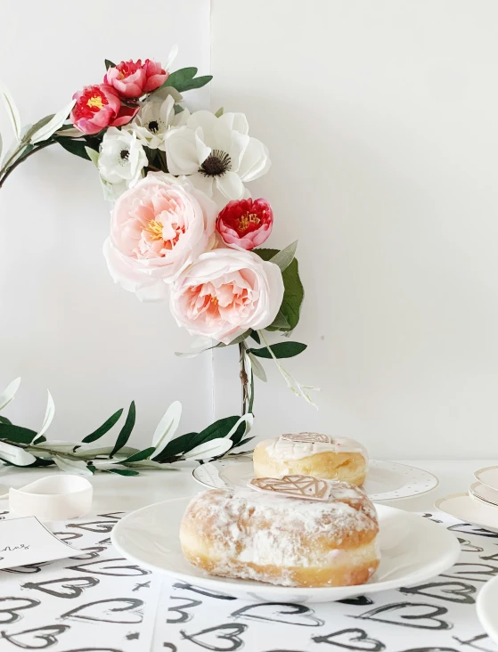 two doughnuts with white and pink flowers on a table