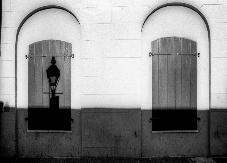 two black and white po of windows, one with a lamp