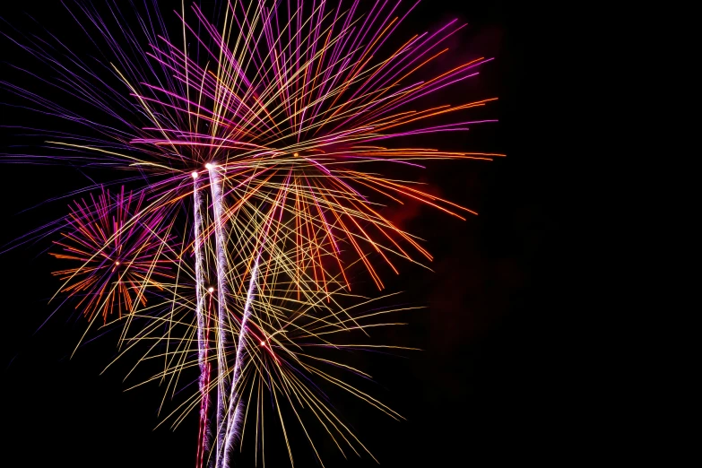 fireworks in the dark with colorful lighting and a black background