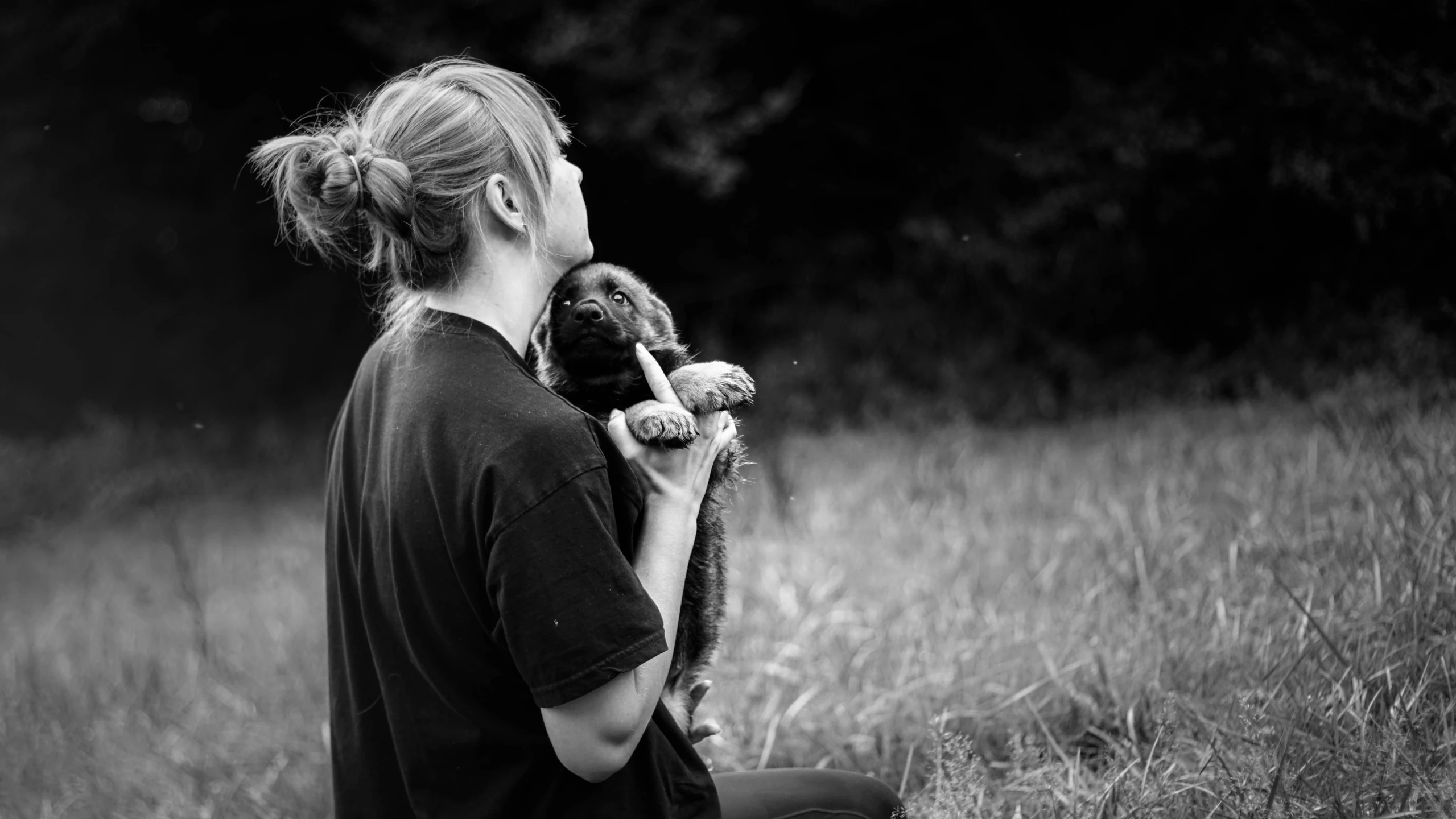 woman holding up her teddy bear in the woods