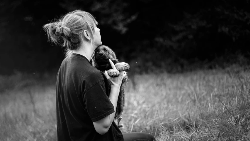 woman holding up her teddy bear in the woods