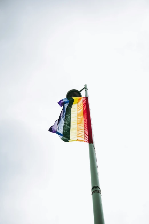 a rainbow colored flag is waving in the wind