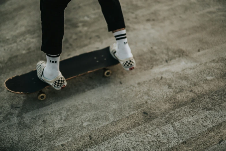 the feet of a skateboarder dressed in white socks