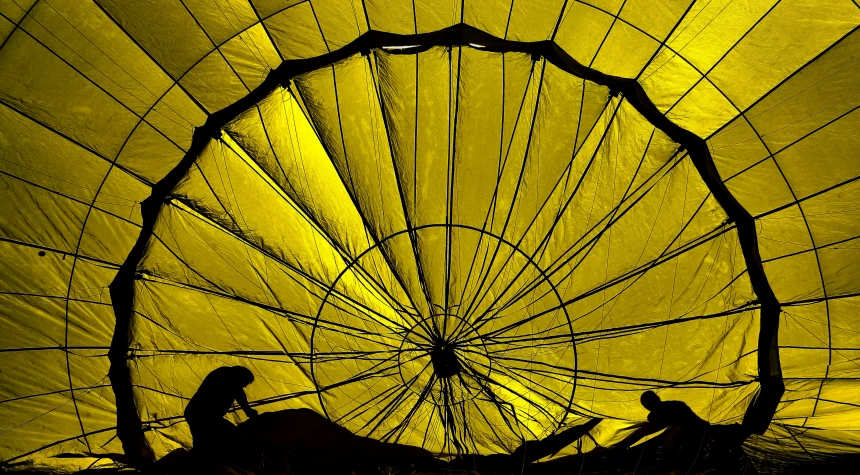 a yellow background shows a silhouetted woman sitting in a basket with the top and bottom of the basket