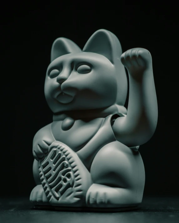 the cat statue is holding an object in it's hand