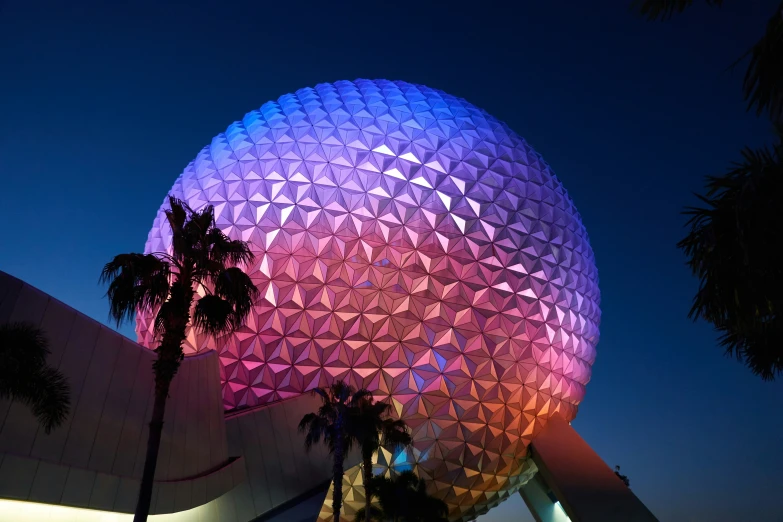 the spaceship building lit up in purple at night