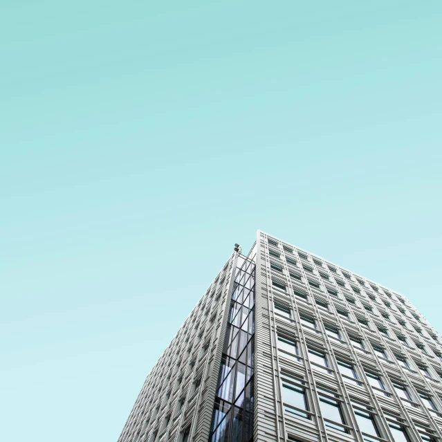 a high - rise building with several windows is shown against the blue sky