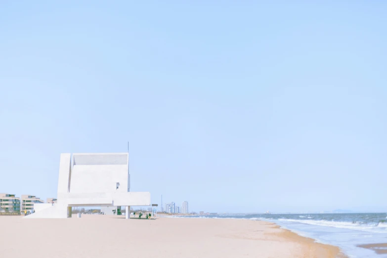 two people standing in the sand by an ocean