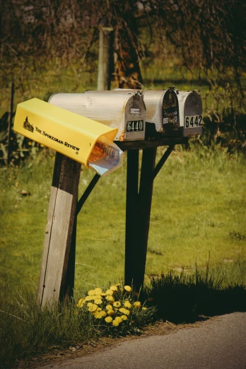 two mailboxes attached to wooden posts are shown