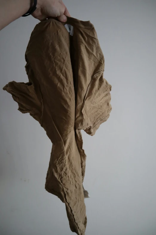 a person holding up an item with fabric hanging from it