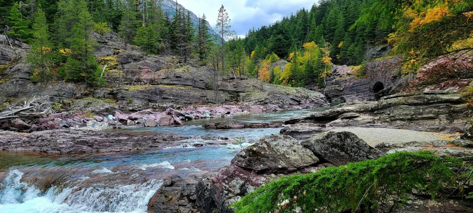 a river runs through the mountains in the fall