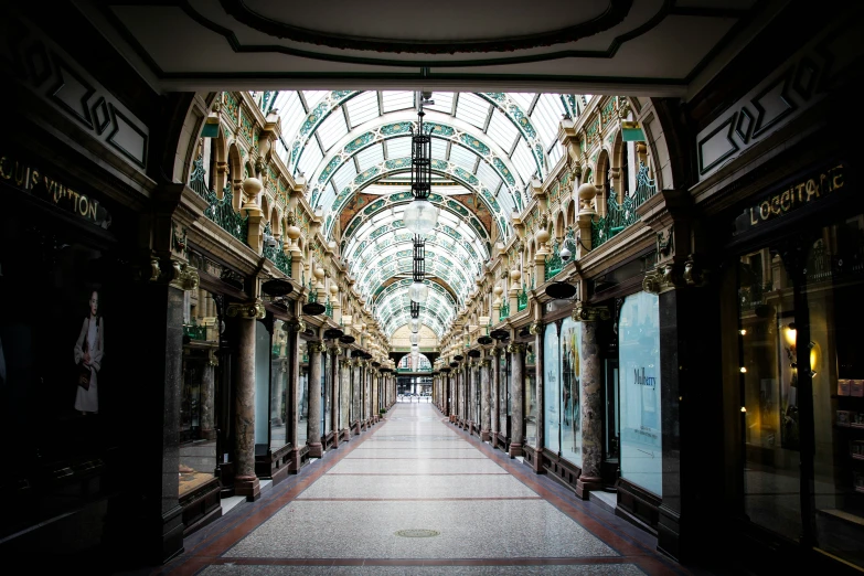 an empty mall with stores and arcades in the background