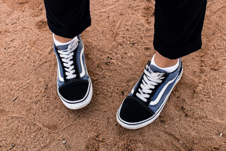 a person standing with their feet wearing tennis shoes